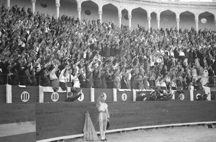 El público de la plaza y Domingo Ortega, escuchando el himno nacional, en la plaza de Albacete. Año 1939